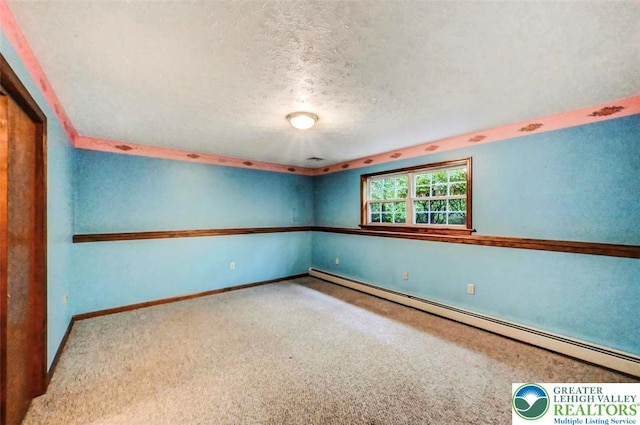 unfurnished room featuring a baseboard heating unit, carpet, a textured ceiling, and baseboards