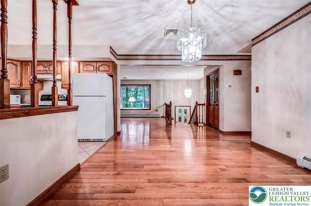unfurnished dining area with light wood-style floors, a chandelier, and baseboards