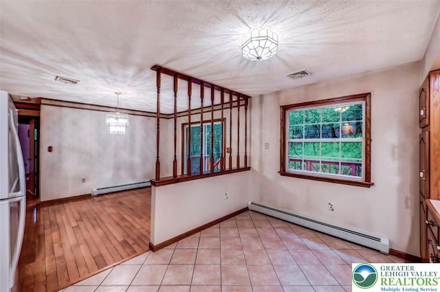 unfurnished room featuring baseboard heating, a baseboard radiator, baseboards, and a chandelier