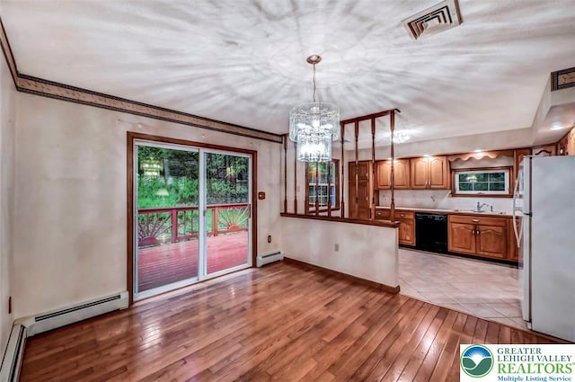 kitchen with freestanding refrigerator, black dishwasher, baseboard heating, light wood finished floors, and a sink