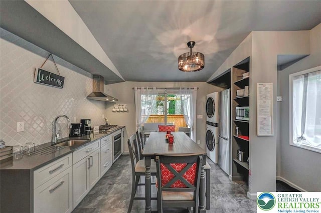 304 Ruger Ln, Coolbaugh Twp, PA 18466 - kitchen with stacked washer and clothes dryer, appliances with stainless steel finishes, wall chimney exhaust hood, a sink, and open shelves
