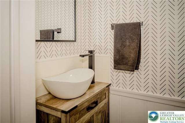 bathroom featuring a decorative wall and vanity