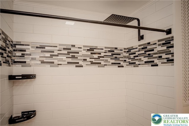 bathroom view of tiled shower and crown molding