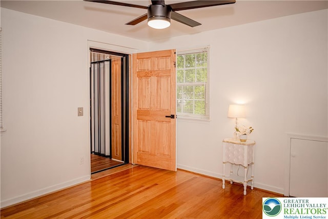 bedroom with light wood-style floors, baseboards, and a ceiling fan