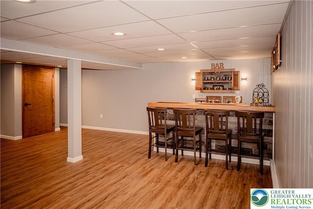 indoor dry bar with wood finished floors, baseboards, and recessed lighting