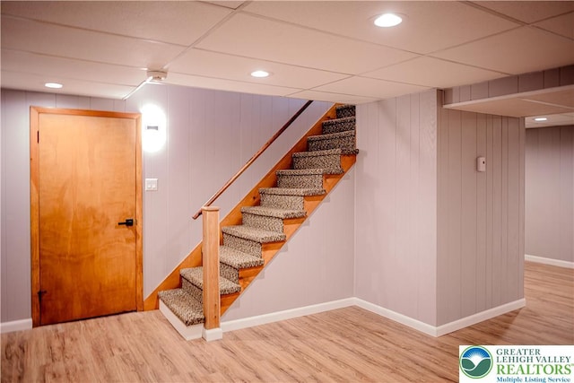 stairway featuring wood finished floors, baseboards, and recessed lighting