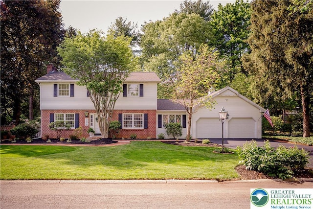 view of front of property featuring a garage, brick siding, asphalt driveway, and a front yard
