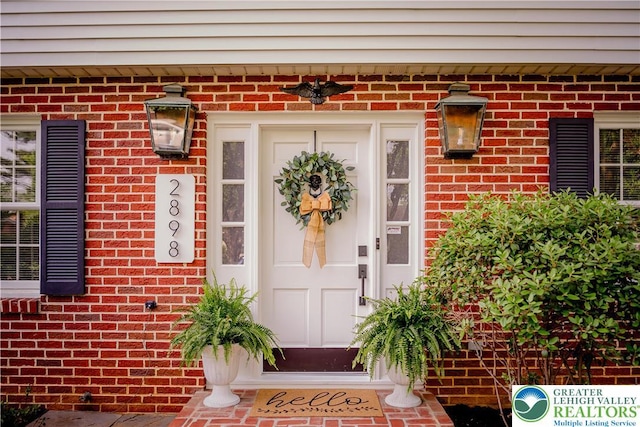 doorway to property featuring brick siding