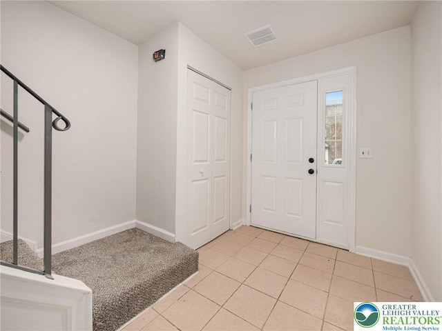 foyer featuring baseboards and light tile patterned floors