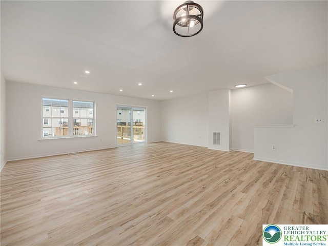 unfurnished living room with light wood-style flooring, recessed lighting, and baseboards