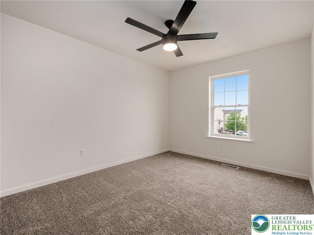 carpeted empty room featuring a ceiling fan and baseboards