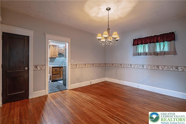 603 S Main St, Bangor Borough, PA 18013 - empty room featuring wood finished floors, a chandelier, and baseboards