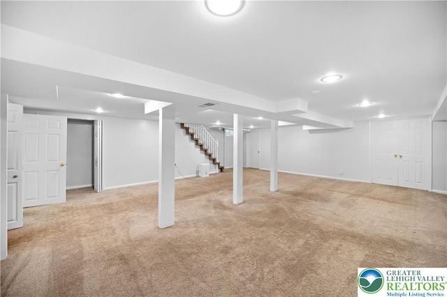 finished below grade area with carpet, stairway, and baseboards