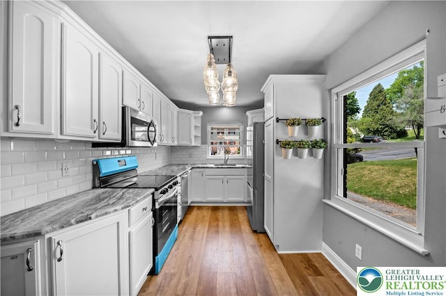 kitchen featuring stainless steel appliances, tasteful backsplash, white cabinets, open shelves, and light wood finished floors