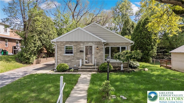 bungalow with a front yard and stone siding