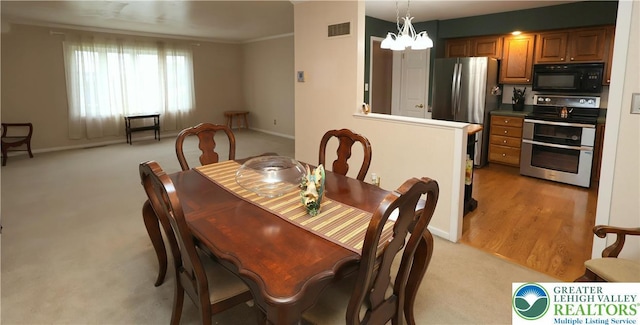 dining room with baseboards, light colored carpet, a chandelier, and crown molding