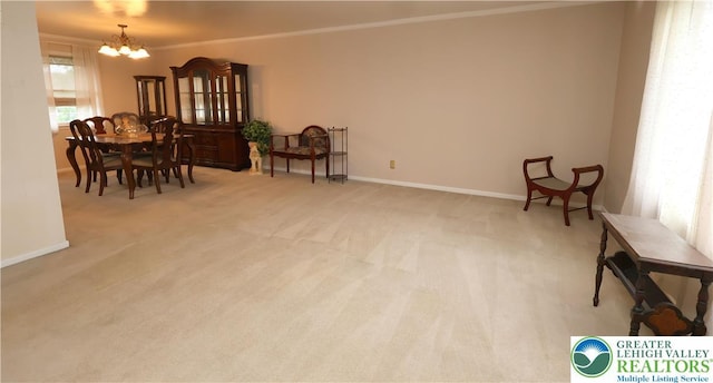 living area with a chandelier, light colored carpet, baseboards, and ornamental molding