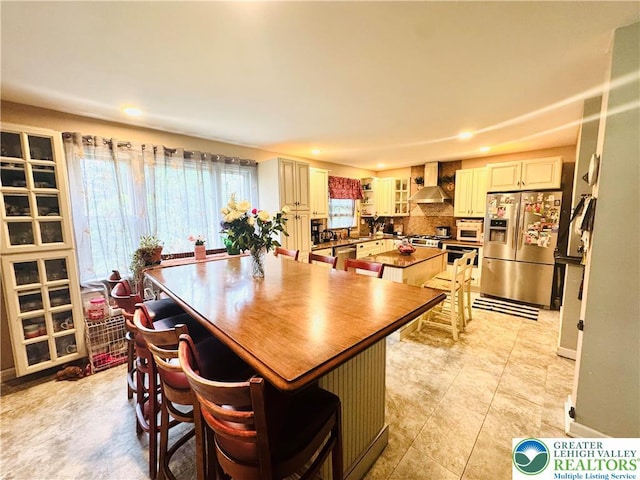 3516 Pine Ave, Saint Lawrence, PA 19606 - kitchen featuring stainless steel appliances, wall chimney range hood, a center island, recessed lighting, and a breakfast bar