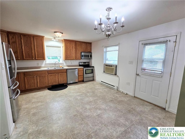 kitchen with stainless steel appliances, a sink, a baseboard heating unit, brown cabinetry, and a chandelier
