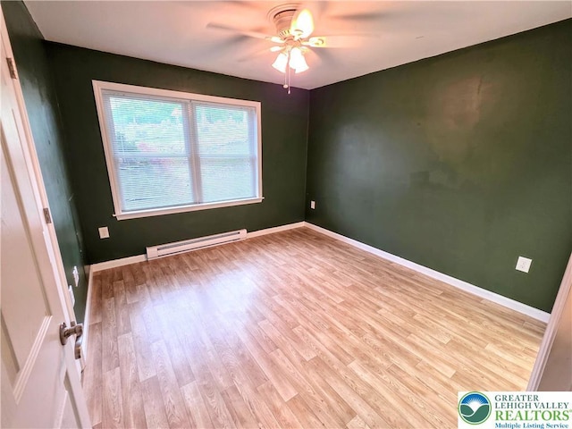 spare room with a baseboard heating unit, wood finished floors, ceiling fan, and baseboards