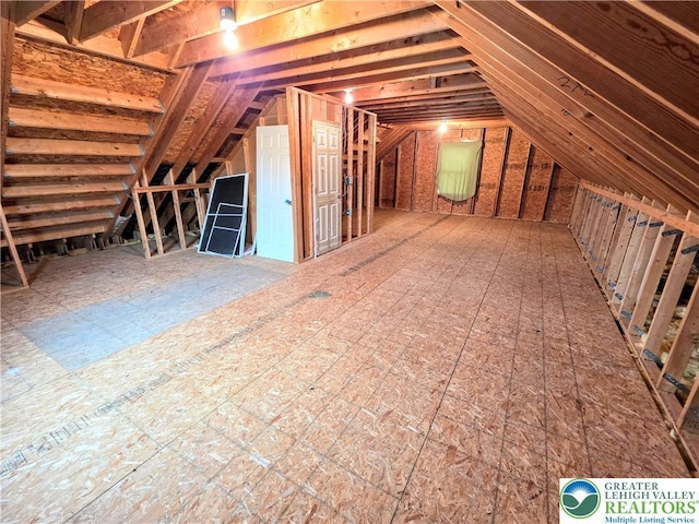 unfinished attic featuring an upstairs landing