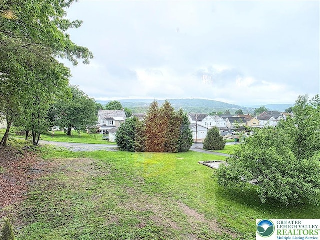 view of grassy yard with a residential view