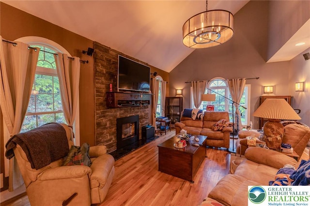 803 Birch Ave, Pen Argyl Borough, PA 18072 - living room featuring high vaulted ceiling, healthy amount of natural light, wood finished floors, a chandelier, and a fireplace