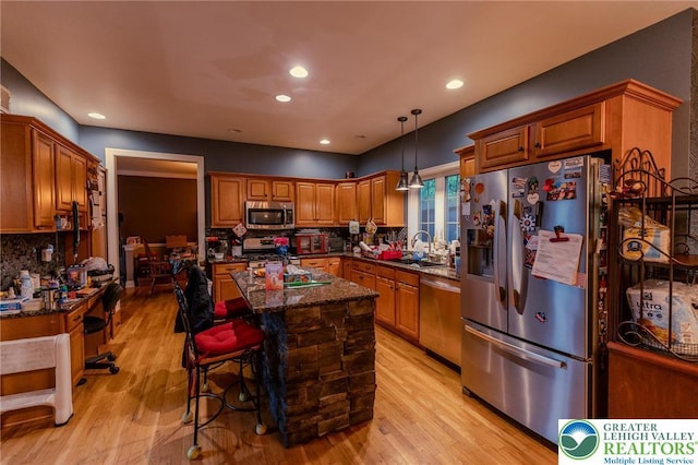 803 Birch Ave, Pen Argyl Borough, PA 18072 - kitchen featuring stainless steel appliances, a sink, light wood-type flooring, decorative backsplash, and a center island