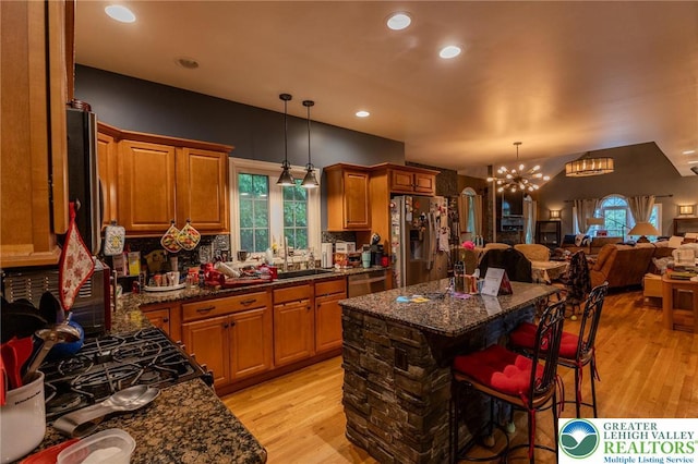 803 Birch Ave, Pen Argyl Borough, PA 18072 - kitchen featuring appliances with stainless steel finishes, light wood finished floors, open floor plan, a chandelier, and backsplash
