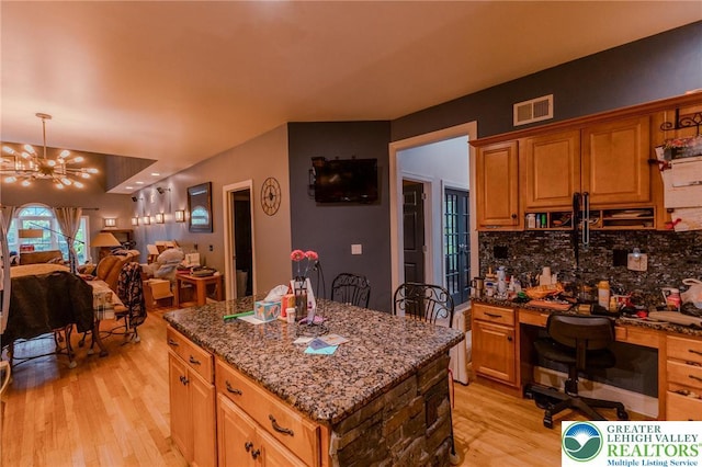 803 Birch Ave, Pen Argyl Borough, PA 18072 - kitchen with light wood-type flooring, tasteful backsplash, dark stone counters, a chandelier, and a kitchen island