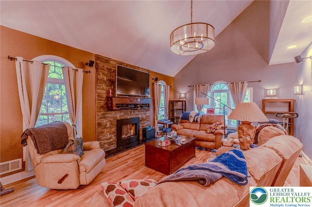 803 Birch Ave, Pen Argyl Borough, PA 18072 - living room with high vaulted ceiling, a chandelier, wood finished floors, a stone fireplace, and baseboards