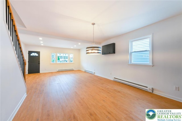 unfurnished dining area featuring a baseboard heating unit, light wood-type flooring, stairway, and recessed lighting