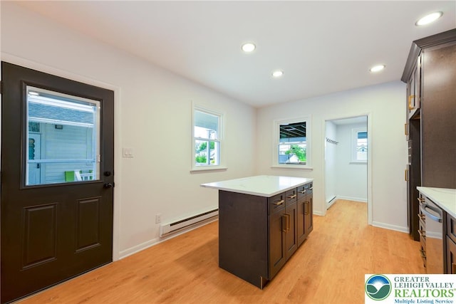 kitchen featuring a baseboard heating unit, light countertops, light wood-style flooring, dishwasher, and a kitchen island