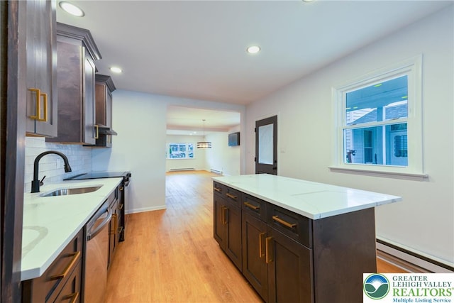 kitchen featuring a sink, stainless steel dishwasher, a baseboard radiator, light wood-type flooring, and backsplash