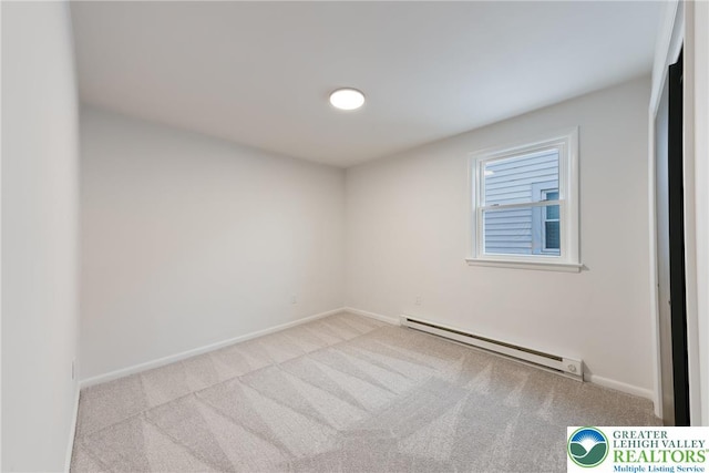 empty room with a baseboard radiator, carpet floors, and baseboards