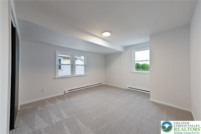 unfurnished room featuring baseboard heating, carpet floors, and baseboards