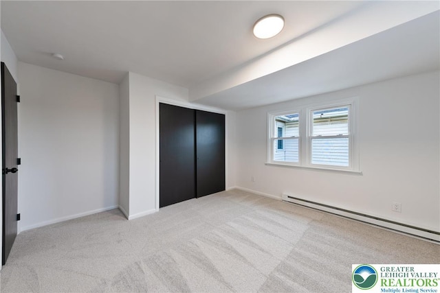 unfurnished bedroom with a baseboard radiator, light carpet, a closet, and baseboards