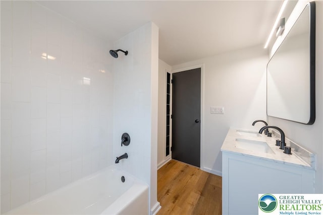 full bath featuring wood finished floors, shower / bath combination, and double vanity