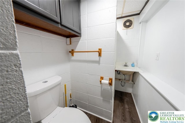 half bathroom featuring wood finished floors and toilet