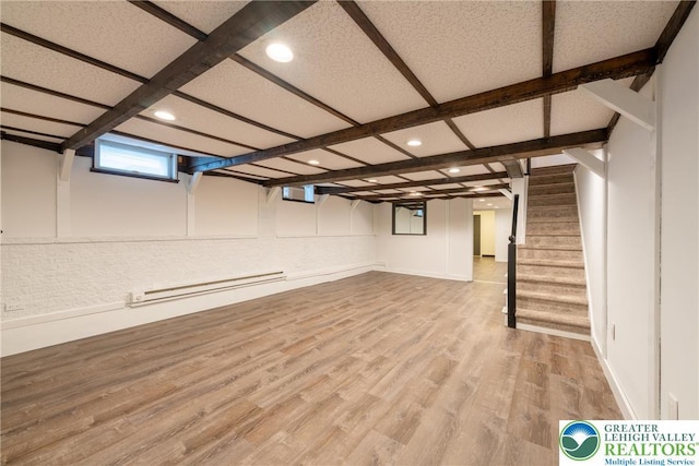 basement with baseboard heating, wood finished floors, stairway, recessed lighting, and baseboards