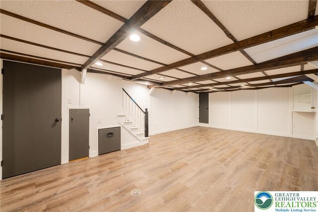 finished below grade area with stairway, recessed lighting, and light wood-type flooring