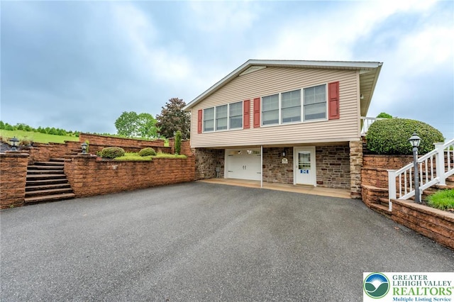 1195 Hemlock St, Lower Towamensing Tp, PA 18071 - view of front of home with asphalt driveway, a garage, stairway, and stone siding