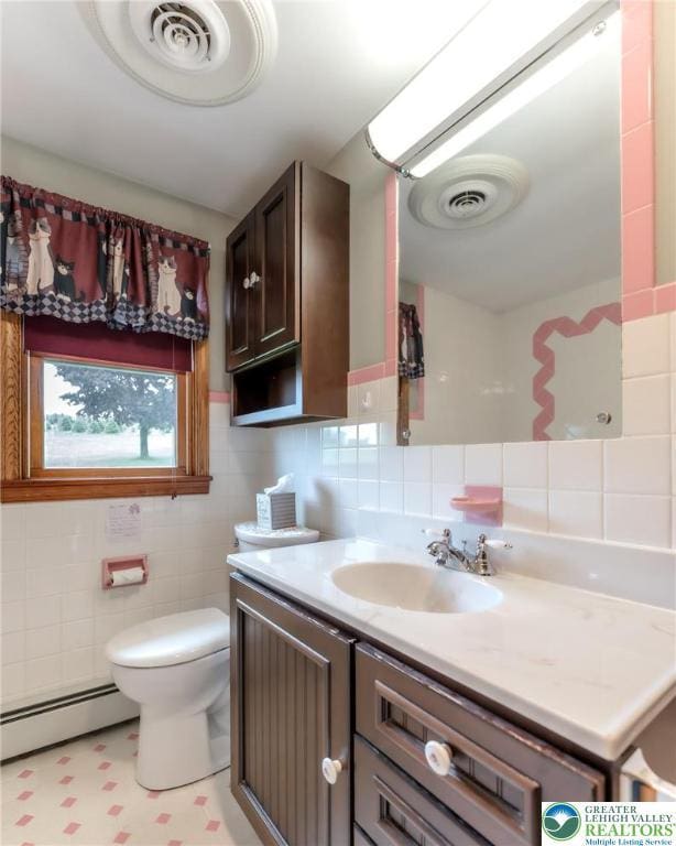 1195 Hemlock St, Lower Towamensing Tp, PA 18071 - half bathroom featuring a baseboard radiator, tile walls, vanity, toilet, and backsplash