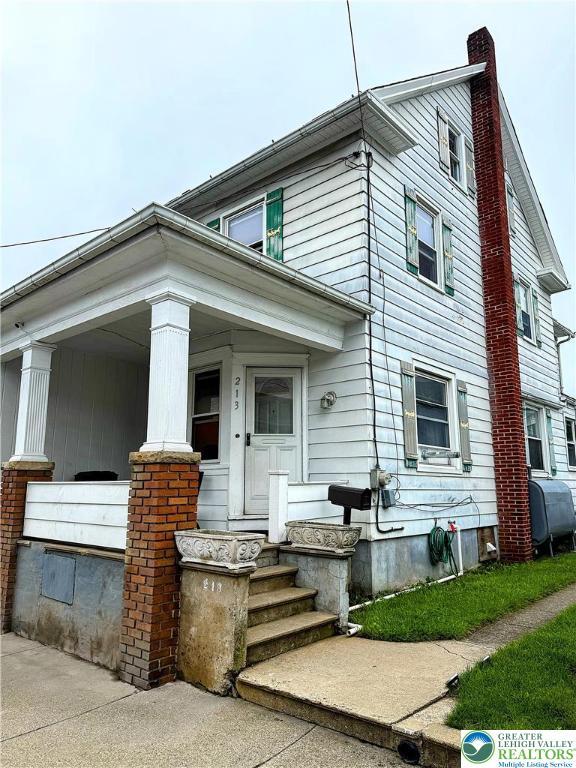 213 Main St, Pen Argyl Borough, PA 18072 - view of front facade featuring heating fuel, a chimney, and a porch