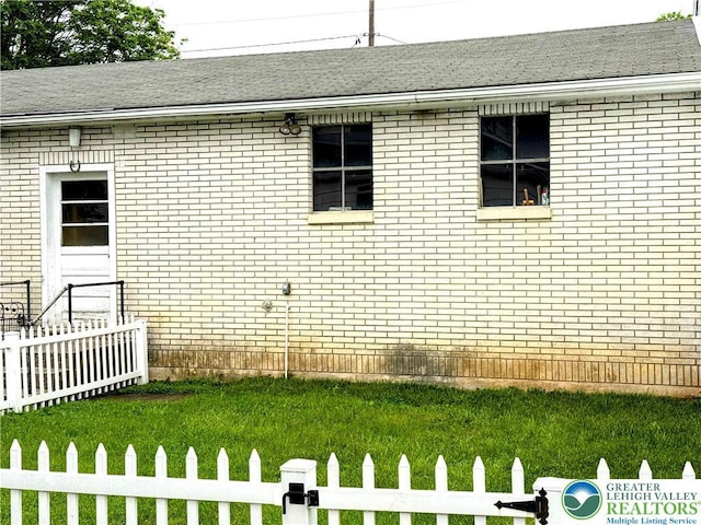 213 Main St, Pen Argyl Borough, PA 18072 - view of side of property with fence, brick siding, and roof with shingles