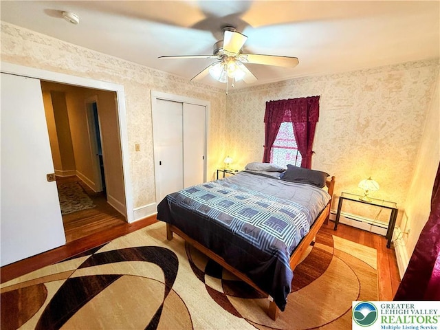 213 Main St, Pen Argyl Borough, PA 18072 - bedroom featuring a baseboard radiator, wood finished floors, wallpapered walls, baseboards, and ceiling fan