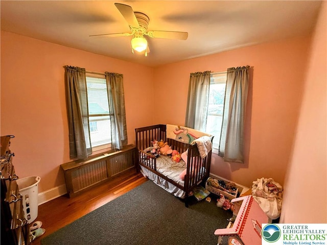 213 Main St, Pen Argyl Borough, PA 18072 - bedroom with a crib, wood finished floors, and a ceiling fan