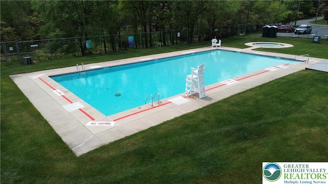 community pool with central AC unit and a hot tub