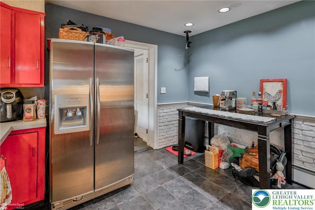 kitchen with stainless steel fridge with ice dispenser, red cabinets, wainscoting, recessed lighting, and light countertops