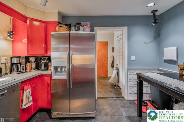 kitchen featuring stainless steel fridge, dishwasher, red cabinetry, and light countertops